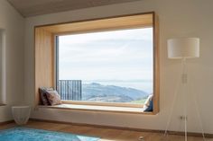 an empty room with a large window overlooking the mountains