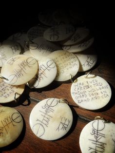 several white buttons with writing on them sitting on a table next to some other items