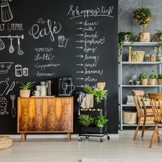 a chalkboard wall in the corner of a room with plants and other things on it