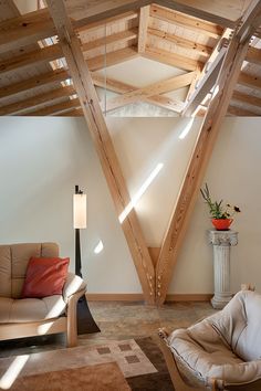 a living room filled with furniture and wooden beams