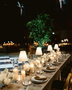 a long table is set with candles, plates and napkins for an elegant dinner