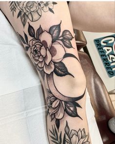 a woman's arm with flowers on it and a crescent in the middle is shown