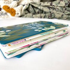 a stack of notebooks sitting on top of a white table