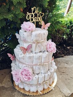 a cake made out of toilet paper with pink flowers and butterflies on top that says oh baby