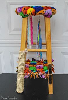 a small wooden stool made out of rope and fabric with colorful decorations on it's seat