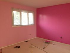 an empty room with pink walls and tools on the floor