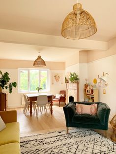 a living room filled with furniture and a large rug on top of a hard wood floor