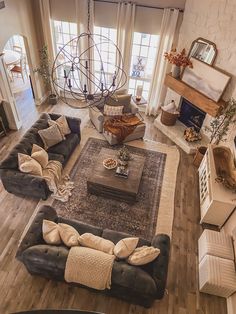 an aerial view of a living room with couches, coffee table and large windows