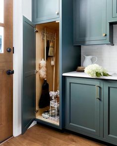 an open cabinet in a kitchen with blue cabinets