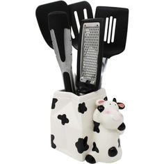 a black and white cow utensil holder with spatulas in it's mouth