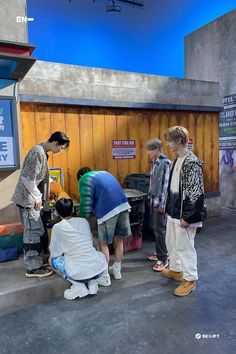 four boys are standing around talking to each other