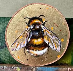 a painting of a bee on a piece of wood