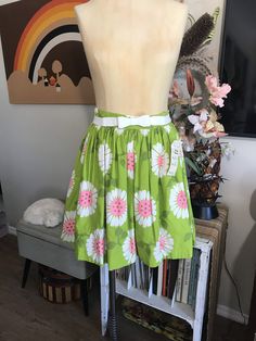 "Cute as can be! Apple green with whimsical flowers in white and neon pink. Attached white cotton and lace petticoat. Two tiny Frey's in fabric at the hem pictured. Easily repaired. Measurements: 26\" waist 42\" free flared hips 70\" circumference at hem 1-3/4\" waistband 7-1/2\" back nylon zipper with two button waist closure 19\" from top of the waistband to hem from the back" Cute Cotton Skirt With Floral Print, Spring Green Cotton Skirt, Green Cotton Skirt For Spring, Green Skirt For Spring Garden Party, Retro Cotton Summer Skirt, White Cotton Skirt For Garden Party, Green Bottoms For Summer Garden Party, Green Retro Skirt For Summer, Retro Green Skirt For Summer