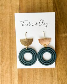 the earrings are made from wood and have two circular rings with gold accents on them