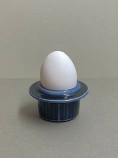 an egg is sitting on top of a blue container with a white substance in it