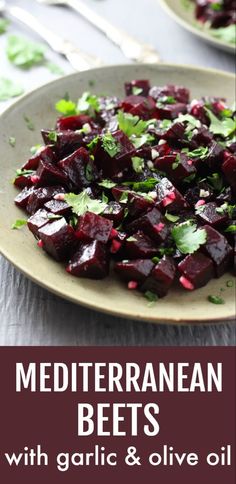 a white plate topped with beets and cilantro on top of a table