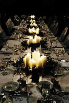 a long table is set with candles and place settings for dinner guests to enjoy the night