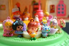 there are many small toy figurines on top of the green cake platter