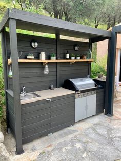 an outdoor kitchen is built into the side of a building with shelves on each side