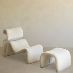 two white chairs sitting next to each other