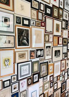 a wall covered in lots of framed pictures