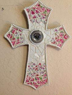 a decorative cross hanging on the side of a wall