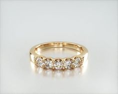 a yellow gold wedding band with five diamonds