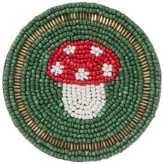 a green and white beaded brooch with a red mushroom on the center, surrounded by smaller beads