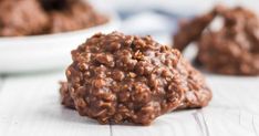 two white bowls filled with chocolate cookies on top of a wooden table next to each other