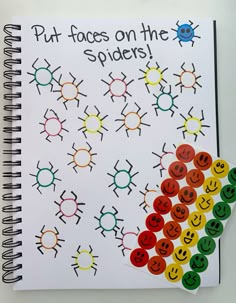 a spiral notebook with smiley faces on the spider's cover and rainbow colored circles