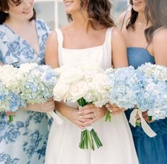 three bridesmaids holding bouquets of blue and white hydrangeas in their hands