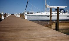 a white boat docked at a wooden dock