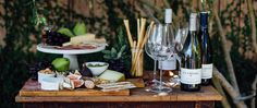 a table topped with bottles of wine and cheese