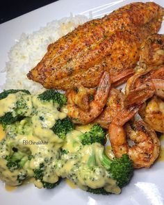 a plate with shrimp, broccoli and rice on it next to some type of sauce