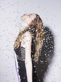 a woman standing under confetti falling from her hair