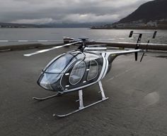 a helicopter sitting on top of a beach next to the ocean