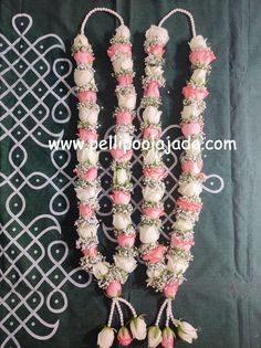 the necklaces are decorated with flowers and pearls on display in front of a green background