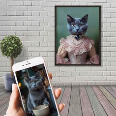 a person holding a cell phone in front of a painting of a cat wearing a pink dress