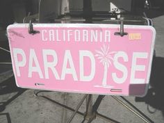 a pink license plate sitting on top of a metal table next to a chair and other items