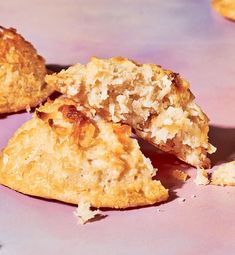 two pieces of food sitting on top of a pink surface with one bite taken out