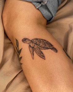 a small turtle tattoo on the leg