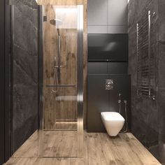 a modern bathroom with wood flooring and black walls, along with a glass enclosed shower stall