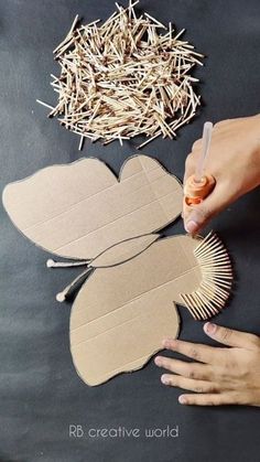 someone is making a paper flower out of cardboard and straw on the table next to it