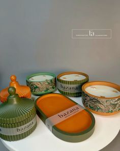 an assortment of candles and containers on a table