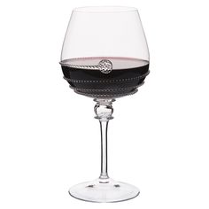 a wine glass filled with red wine on top of a white table