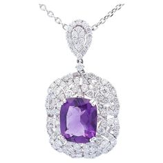 Quality, at the right price. This designer slide pendant features a 4.39 carat cushion shaped amethyst as the center stone. Surrounding the amethyst are round diamonds with a total carat weight of 2.37 carats and baguette diamonds with a total carat weight of .08 set in 18K white gold. The pendant also has a chain included. The chain is 4.6 GR and is a 14K white gold D/C chain with a thickness of 1.7 MM with a length of 20 inches. This stunning necklace features amethyst set and arranged in the White Gold Amethyst Pendant Jewelry, Amethyst Pendant With Diamond Accents, Luxury Oval Amethyst Pendant, Luxury Large Amethyst Pendant Jewelry, Designer Slides, Luxury Amethyst Large Pendant Jewelry, Amethyst Set, Amethyst Pendant, Stunning Necklace