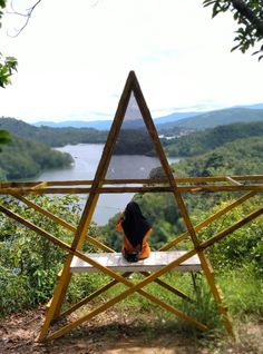 a person sitting on top of a wooden structure