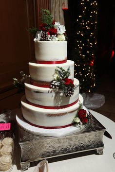 a three tiered wedding cake with red and white decorations