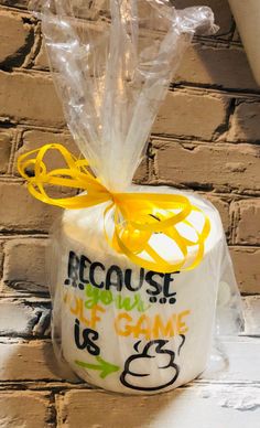 a plastic bag with some yellow ribbon around it on top of a white brick wall