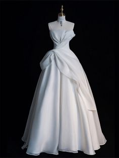 a white wedding dress with a bow on the waist and neckline is shown in front of a black background